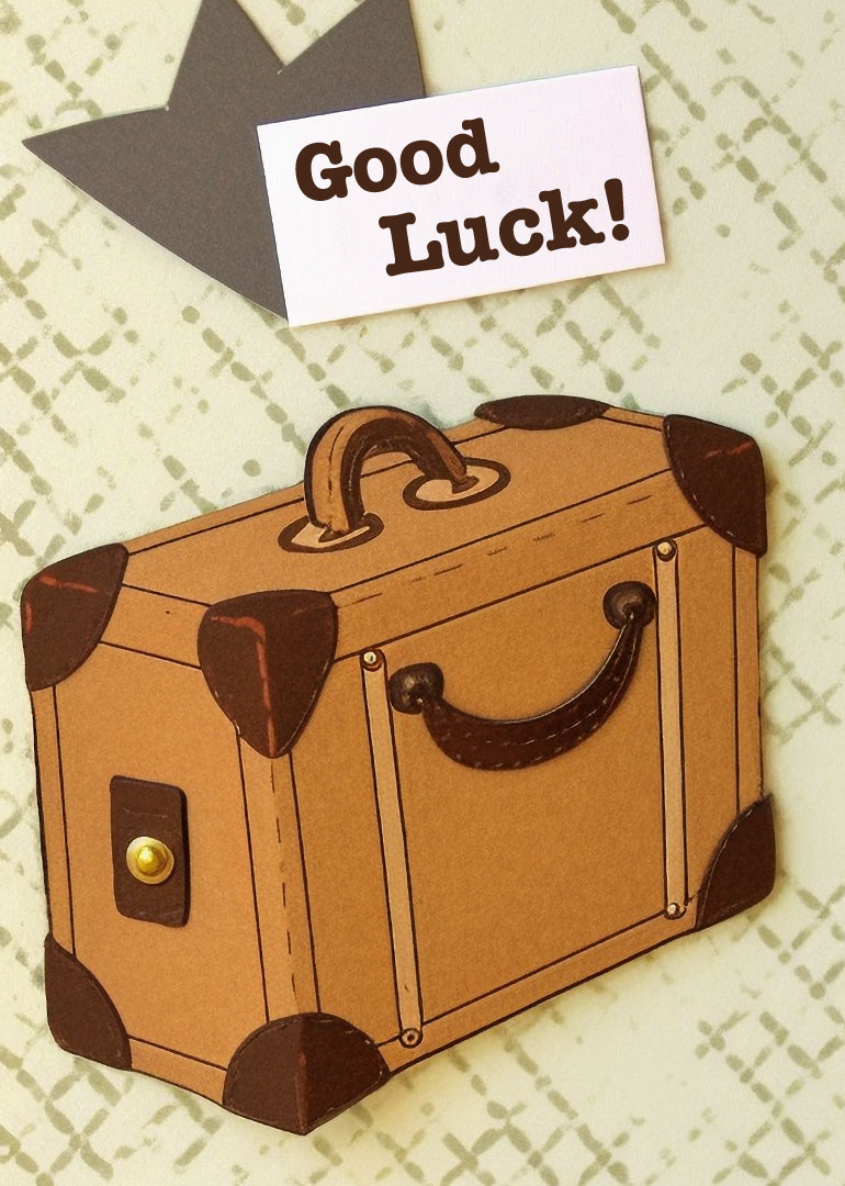 Vintage suitcase with a 'Good Luck!' message on a patterned background